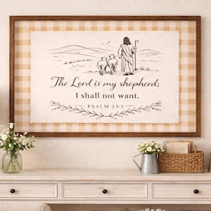 May include: A framed artwork with a pastoral scene of a shepherd and sheep, with the text "The Lord is my shepherd; I shall not want." The frame has a brown border and a tan and white checkered background.