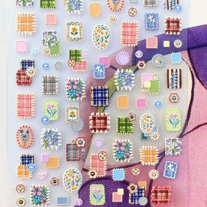 May include: A clear sheet of decorative stickers featuring various floral and plaid designs. The stickers are in the shape of postage stamps, squares, and ovals, with a variety of colors including pink, blue, green, and orange. Some stickers have a stitched border.