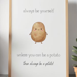 Könnte beinhalten: Ein gerahmter Druck mit einem hellen Holzrahmen. Der Druck zeigt eine Cartoon-Kartoffel mit einem lächelnden Gesicht und dem Text "always be yourself unless you can be a potato then always be a potato!"