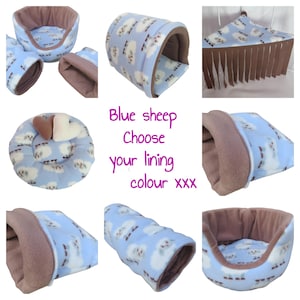 May include: A collection of small animal bedding items featuring a light blue fleece fabric with a white sheep pattern and brown interior lining. The set includes a round bed, a tunnel, a corner hammock with fringe, and a pouch, with text reading Blue sheep Choose your lining colour xxx.