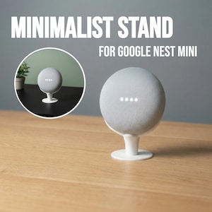 May include: A white minimalist stand for a Google Nest Mini speaker. The speaker is light gray and spherical, with four illuminated dots. The stand is on a wooden surface, with the text "MINIMALIST STAND FOR GOOGLE NEST MINI" in white.