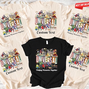 May include: A collection of cream and black t-shirts featuring a colorful graphic design with the text "UNIVERSAL Studios". The design includes various cartoon characters and the phrase "Making Memories Together". Some shirts have "Custom Text".