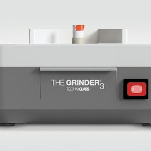 May include: A gray and white electric grinder with the text "THE GRINDER 3 TECHNIGLASS". It has a red power button and a handle. The grinder is designed for a specific purpose.