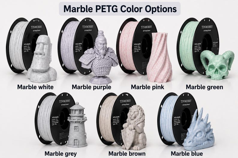 May include: Image showcasing various 3D printing filament colors, including marble white, purple, pink, green, grey, brown, and blue. Each color is displayed with a 3D-printed model and a spool of filament. Text at the top reads "Marble PETG Color Options."