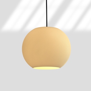 May include: A beige, spherical pendant light fixture with a textured surface. The light hangs from a black cord and emits a soft glow from the bottom. The fixture has a ribbed pattern and is suspended against a white background.