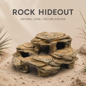 Könnte beinhalten: Ein beigefarbenes und braunes Felsenversteck für Kleintiere mit geschichteten, strukturierten Oberflächen und mehreren Öffnungen. Der Text ROCK HIDEOUT NATURAL LOOK • SECURE SHELTER steht über der Struktur, die von Sand und Pflanzen umgeben ist.