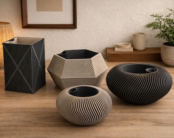 Peut inclure: Une collection de vases décoratifs de différentes formes et tailles. Les vases sont fabriqués à partir de matériaux texturés dans des tons neutres de noir, beige et crème. Un vase est cylindrique, un autre hexagonal et deux sont sphériques. Les vases sont disposés sur une surface en bois.