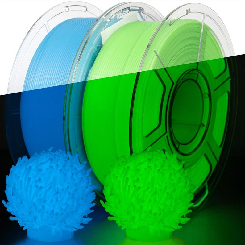 May include: Spools of blue and green 3D printing filament are displayed, alongside two glowing, textured, spherical objects in matching colors. The filament is wound on clear plastic spools. The objects appear to be 3D printed as well.