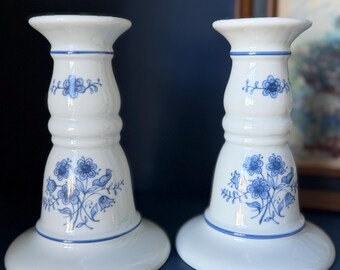Coppia di candelabri vintage in ceramica blu e bianca con decorazioni floreali.