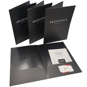 May include: Black presentation folders with the text "BRICK & GALO REALTY" in white. One folder is open, revealing a pocket with a business card and a card that says "EDASI Rewards ONYX PASS".