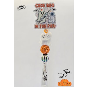 Puede incluir: Un portatarjetas con un adorno rectangular brillante que muestra un fantasma enfermero, una jeringa y el texto CODE BOO IN THE PICU. Debajo hay dos dijes de fantasmas blancos, una cuenta naranja brillante, una cuenta a rayas y un estetoscopio.