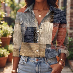May include: A long-sleeve button-down shirt featuring a multi-colored geometric patchwork pattern in shades of blue, tan, and burnt orange. The shirt has a classic collar, a front button placket with white buttons, and long sleeves with cuffs.