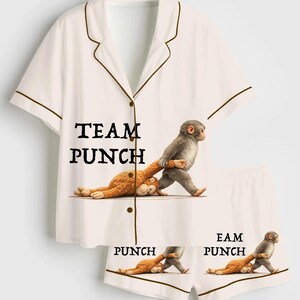 Puede incluir: Conjunto de pijama blanco con ribete marr&oacute;n, con el texto "TEAM PUNCH" en la camisa y "PUNCH" en los pantalones cortos. El dise&ntilde;o incluye un mono de dibujos animados golpeando a un peluche. El conjunto es de material suave.
