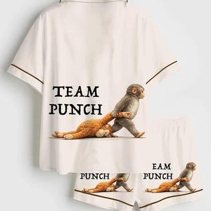 Puede incluir: Conjunto de pijama blanco con ribete marr&oacute;n, con el texto "TEAM PUNCH" en la camisa y "PUNCH" en los pantalones cortos. El dise&ntilde;o incluye un mono de dibujos animados tirando de otro mono. Un conjunto de ropa de dormir divertido y juguet&oacute;n.
