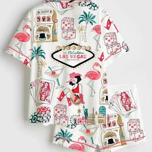 May include: White short-sleeved shirt and shorts set with a Las Vegas theme. The set features illustrations of slot machines, dice, playing cards, flamingos, and the text "Welcome to Fabulous Las Vegas Nevada."