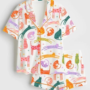 Może przedstawiać: Zestaw trzech ceramicznych kubk&oacute;w z nakrapianym, matowym wykończeniem. Kubki są w odcieniach kremu, jasnoszarym i ciemnoszarym. Każdy kubek ma prosty, minimalistyczny design.