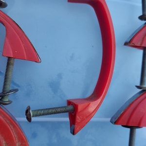 Red Vintage/Mid Century Modern curved drawer or cabinet pulls. Early plastic or Bakelite with chrome finish accent strip.