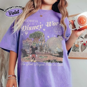 Puede incluir: Una camiseta violeta Comfort Colors con un gr&aacute;fico de Disney World. El dise&ntilde;o incluye el texto "FLORIDA Est. 1971 Disney World" y una imagen de Mickey Mouse, la Hollywood Tower y la bola de Epcot. La camiseta tambi&eacute;n tiene el texto "The Most Magical Place On Earth."