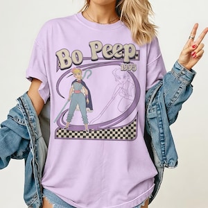 Puede incluir: Una taza de cer&aacute;mica blanca con un asa negra y el texto "But First, Coffee" en negrita negra. La taza se encuentra sobre un fondo borroso, sugiriendo un ambiente acogedor.