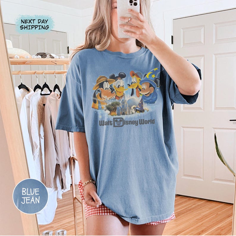 Pu&ograve; includere: T-shirt blu jeans con grafica dei personaggi Disney, tra cui Topolino, Paperino e Pippo, con la scritta "Walt Disney World". La maglietta ha una vestibilit&agrave; comoda e oversize.