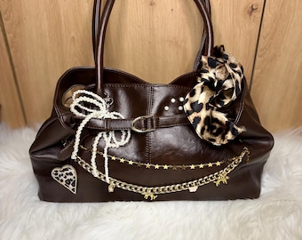 Bolso de hombro marrón estilo Y2K con lazo de leopardo y dijes. Bolso de mano de estética coqueta y estilo vintage chic.