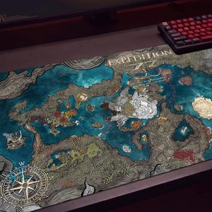 May include: A rectangular desk mat featuring a detailed fantasy map illustration with blue water, grey landmasses, and a compass rose in the bottom left corner. The text "EXPEDITION" is printed in white at the top center of the mat, which is placed on a desk.