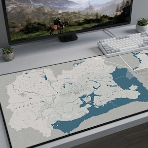 Puede incluir: Alfombrilla de escritorio rectangular con un dise&ntilde;o de mapa en tonos grises y azules. El mapa muestra caracter&iacute;sticas geogr&aacute;ficas y etiquetas de texto. La alfombrilla tiene un borde negro y el texto "PYWEL CONTINENT" es visible. El logotipo de Artisan Desk Mats est&aacute; en la esquina inferior derecha.