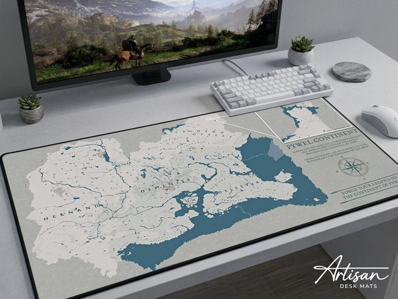 Puede incluir: Alfombrilla de escritorio rectangular con un dise&ntilde;o de mapa en tonos grises y azules. El mapa muestra caracter&iacute;sticas geogr&aacute;ficas y etiquetas de texto. La alfombrilla tiene un borde negro y el texto "PYWEL CONTINENT" es visible. El logotipo de Artisan Desk Mats est&aacute; en la esquina inferior derecha.