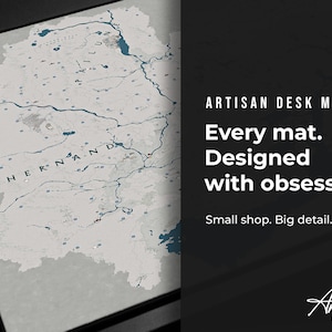 Puede incluir: Una alfombrilla de escritorio con un dise&ntilde;o de mapa detallado en tonos grises y azules. El texto "HERNAND" es visible en el mapa. La imagen tambi&eacute;n incluye el texto "ARTISAN DESK MATS" y "Every mat. Designed with obsession. Small shop. Big detail."