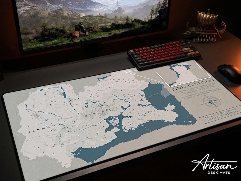 Puede incluir: Una alfombrilla de escritorio grande con un dise&ntilde;o de mapa detallado en tonos azules y grises. El mapa incluye caracter&iacute;sticas geogr&aacute;ficas y texto, con las palabras "PYWEL CONTINENT" y "Artisan DESK MATS" visibles. Un teclado y un rat&oacute;n tambi&eacute;n est&aacute;n en el escritorio.