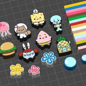 Puede incluir: Una colección de dijes para zapatos con temática de dibujos animados que incluye una esponja amarilla, una estrella de mar rosa, un cangrejo, una ardilla, una medusa, una casa piña, una hamburguesa y flores, junto a bloques rectangulares de colores.