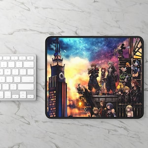 May include: A rectangular mousepad featuring a vibrant illustration of characters from the Kingdom Hearts video game series. The design includes a cityscape with a clock tower, and a colorful sky. The mousepad has a black border.