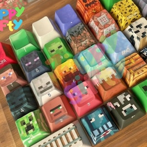 Peut inclure: Un ensemble de touches de clavier personnalisées colorées avec des motifs pixélisés inspirés d'un jeu vidéo populaire. Les touches présentent divers personnages et icônes, dont un Creeper, Steve et Enderman. Les touches sont disposées dans un boîtier en plastique transparent.