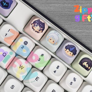 Puede incluir: Primer plano de un teclado con teclas personalizadas. Las teclas presentan ilustraciones coloridas de personajes de anime y letras y símbolos en colores pastel. El texto "Zippy Fty" es visible.