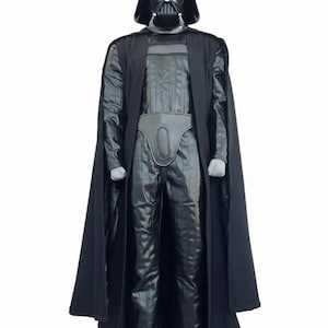 Full-body shot of a high-quality handmade Darth Vader cosplay costume with a long black flowing cape, quilted flight suit jumpsuit, inner tunic, and soft parts, displayed on a model against a clean, solid white background.
