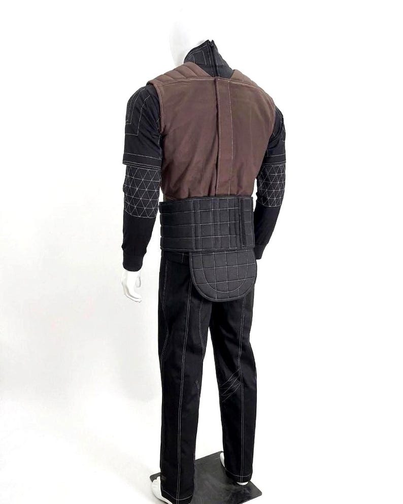 A premium galactic bounty hunter cosplay costume worn by a male model looking sideways, showcasing the screen-accurate ribbed double-sleeve detailing, dark brown flak vest, and black tailored undersuit over a solid white background.