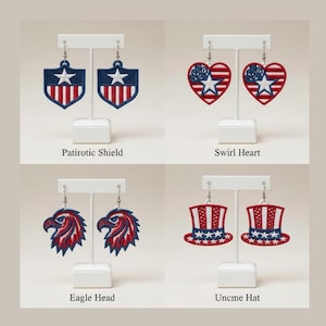 May include: Embroidered patriotic earrings in shield, heart, eagle head, and Uncle Sam hat designs. Each earring is red, white, and blue, with a star and stripe motif. The earrings are displayed on white stands.