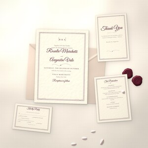 May include: A wedding invitation suite on cream textured paper with dark maroon script and serif text. Includes a main invitation, a thank you card, a particulars card, and a reply card, all featuring thin borders and two maroon wax seals.