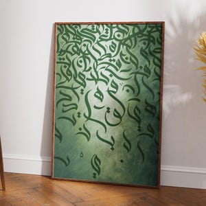 Puede incluir: Una obra de arte enmarcada con caligrafía árabe verde sobre un fondo degradado. La caligrafía está en una escritura fluida, con una mezcla de trazos gruesos y finos. El marco es de color madera oscura. La obra de arte está apoyada contra una pared blanca.
