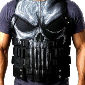 Può includere: Gilet tattico nero con un disegno a teschio sul petto. Il gilet ha più cinghie e tasche ed è indossato sopra una maglietta blu scuro. Il disegno del teschio è principalmente bianco e grigio.