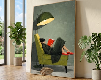 Op de afbeelding: Een ingelijste kunstdruk toont een persoon die een rood boek leest in een groene fauteuil. Een groene lamp verlicht de scène, met een stapel boeken op de vloer. De persoon draagt een zwarte jurk en rode schoenen.