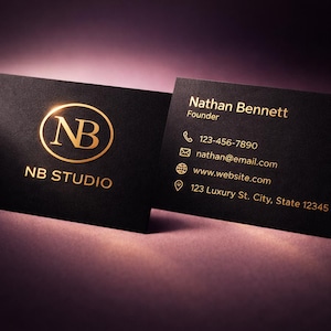 May include: Two black business cards with gold foil lettering. One card displays the initials "NB" inside a gold circle, with "NB STUDIO" below. The other card lists contact information: name, phone, email, website, and address.