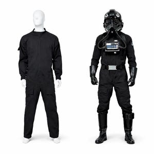 Puede incluir: Dos trajes negros sobre maniquíes. Uno es un mono sencillo. El otro es un uniforme de piloto con casco, peto, guantes y botas. El uniforme de piloto tiene un cinturón con hebilla plateada.