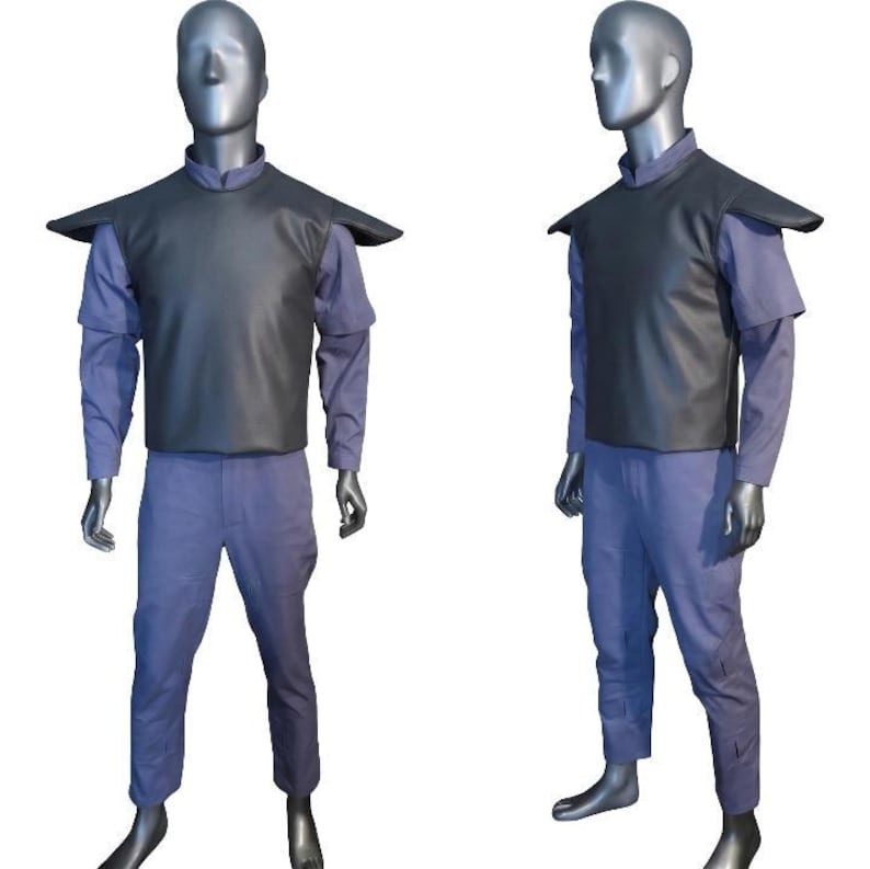 K&ouml;nnte beinhalten: Ein zweiteiliges Kost&uuml;mset bestehend aus einer schwarzen &auml;rmellosen Weste mit ausgepr&auml;gten Schulterpolstern, getragen &uuml;ber einem hellvioletten Langarmshirt und einer passenden hellvioletten Hose. Das Outfit wird auf einer grauen Schaufensterpuppe gezeigt.