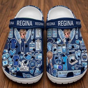 May include: Navy blue clogs with a white sole, featuring a pattern of medical icons, CNA angels, and the name "Regina." The design includes medical equipment, pills, and the text "CNA: The Heart & Patient Care."