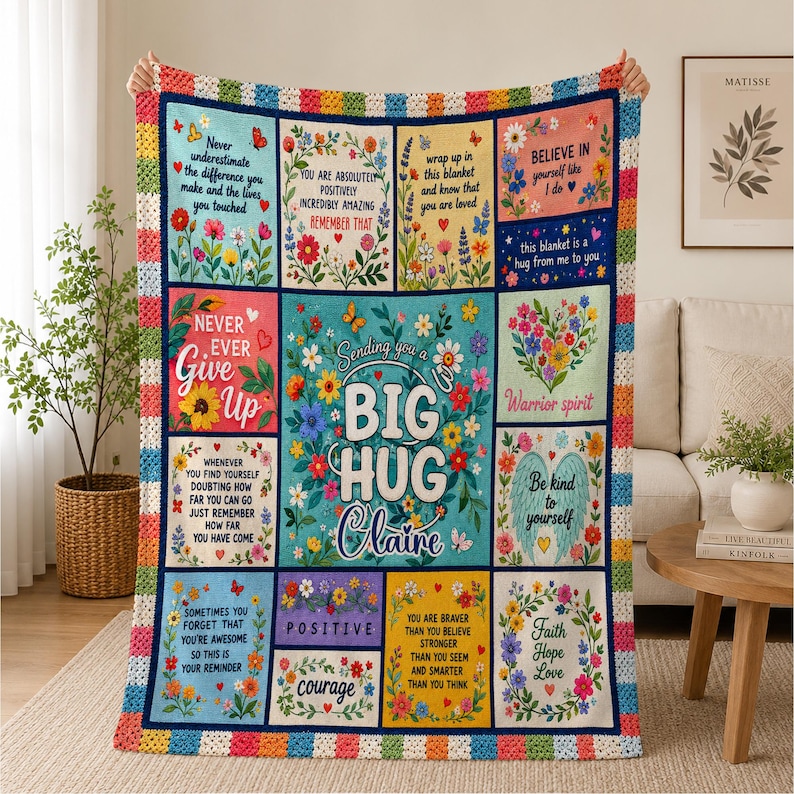 May include: A multi-colored crochet-bordered throw blanket featuring a grid of floral panels with inspirational text including "Sending you a BIG HUG Claire," "Never ever give up," "Believe in yourself," and "Be kind to yourself."
