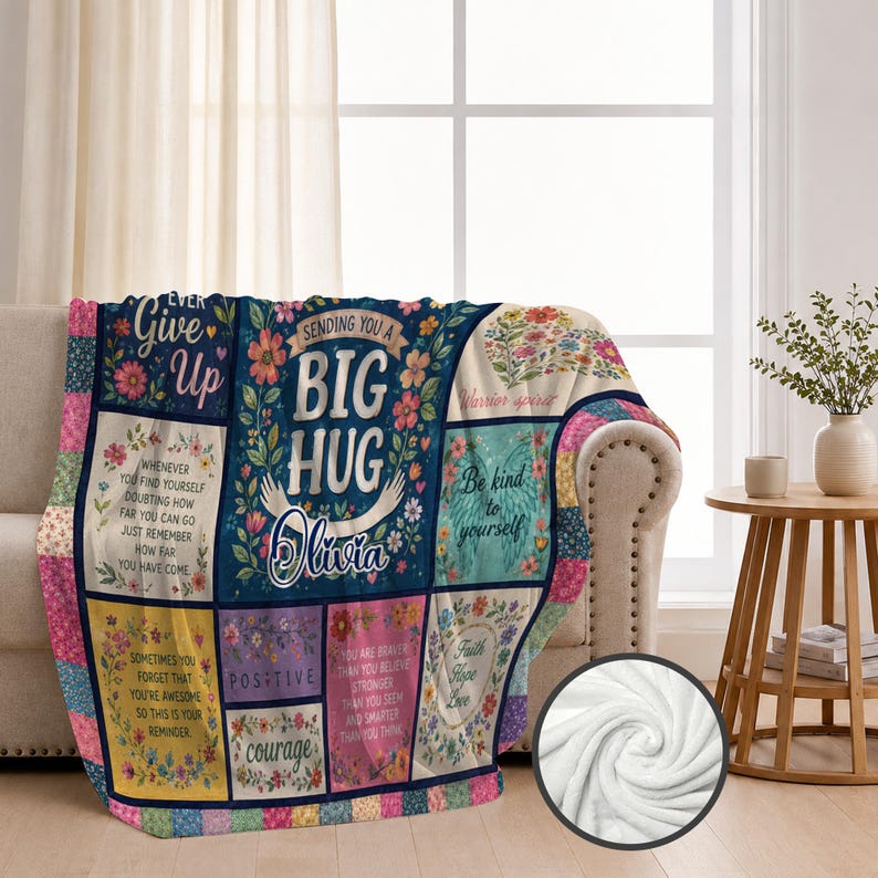 May include: A rectangular throw blanket featuring a patchwork design with floral patterns and inspirational text including "Sending you a big hug," "Olivia," "Never give up," "Be kind to yourself," "Positive," "Courage," and "Faith Hope Love."