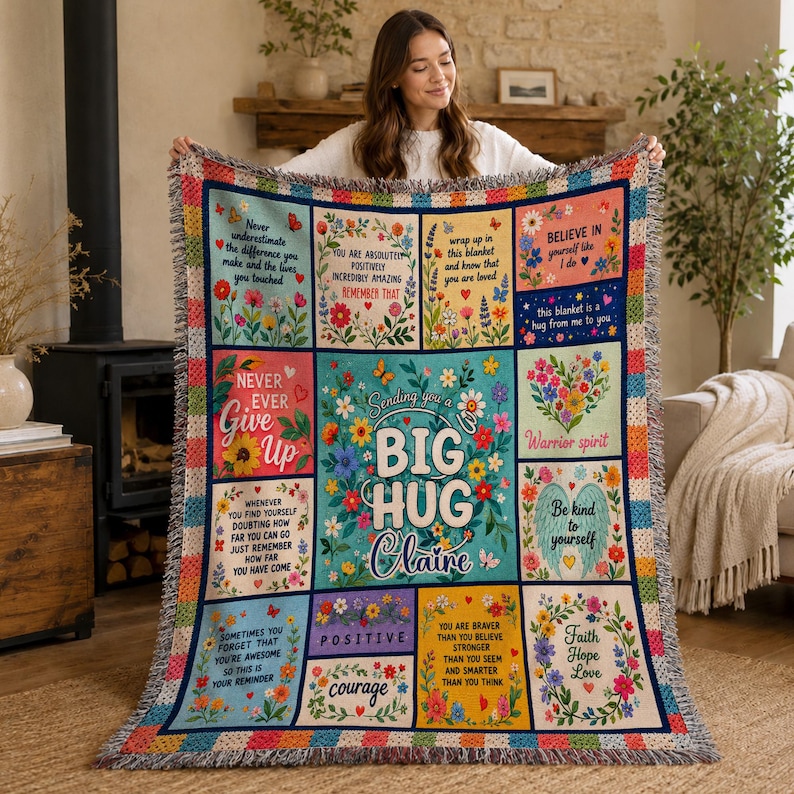 May include: A woven throw blanket featuring a grid of colorful floral panels with inspirational quotes and the text 'Sending you a BIG HUG Claire'. The design includes hearts, butterflies, and encouraging messages in various fonts on a multi-colored background.