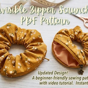 May include: Mustard yellow scrunchies with a floral design, one open to show a satin interior. The image includes sewing supplies such as a tape measure, scissors, and thread. Text reads "Invisible Zipper Scrunchie PDF Pattern."