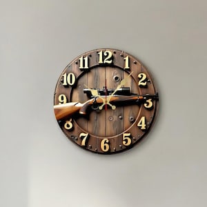 Può includere: Un orologio da parete rotondo in legno con un design a fucile. Il quadrante dell'orologio è marrone con numeri e lancette dorate. Il fucile è posizionato orizzontalmente al centro dell'orologio, aggiungendo un tocco rustico.